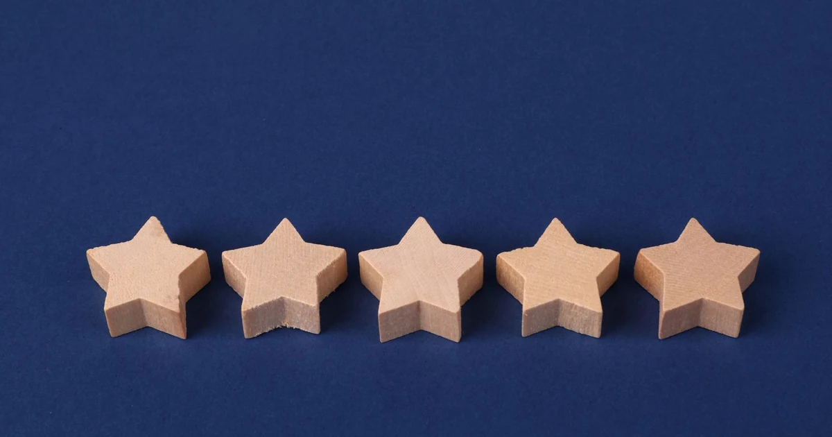 Cinq etoiles en bois alignees sur un fond bleu, note de satisfaction