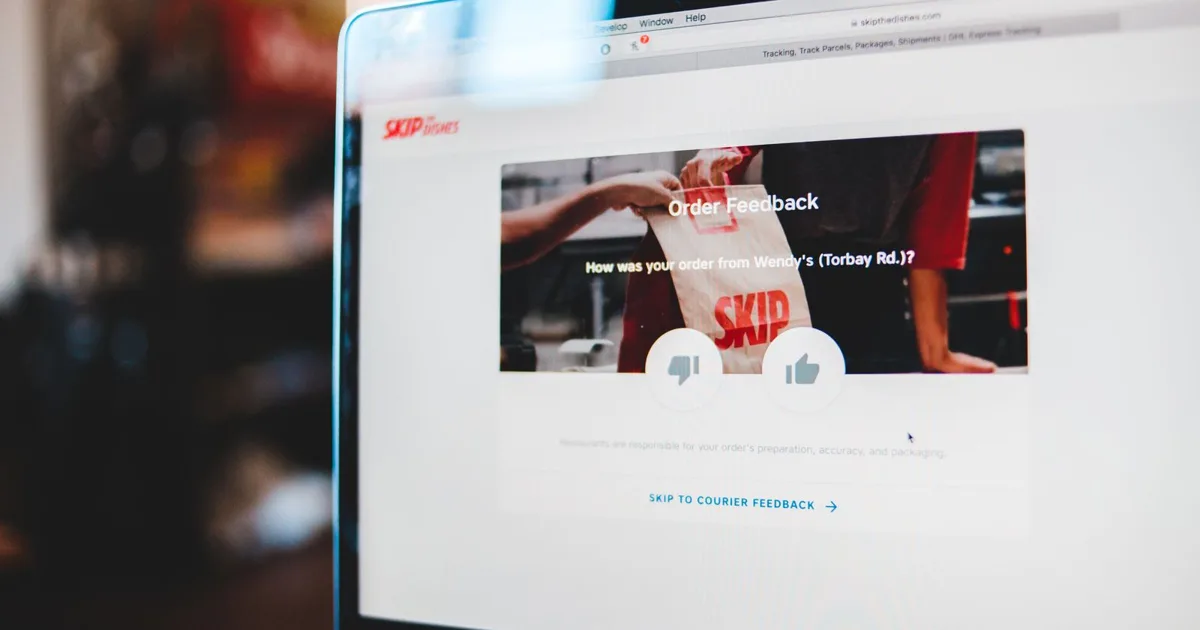 Laptop screen showing an order feedback form with thumbs up and thumbs down buttons
