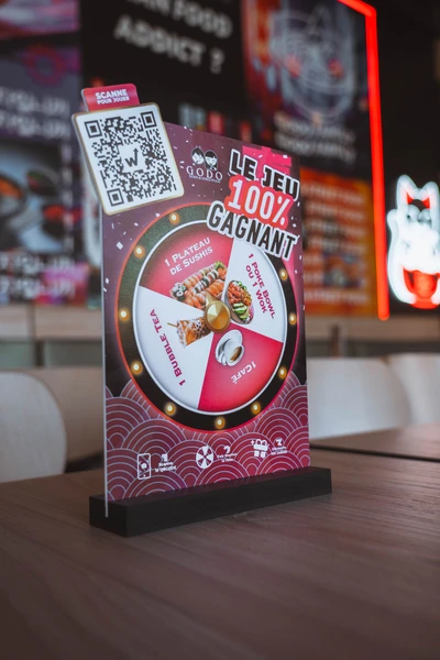 Godo Sushi 100% winning game stand with QR code on a restaurant table