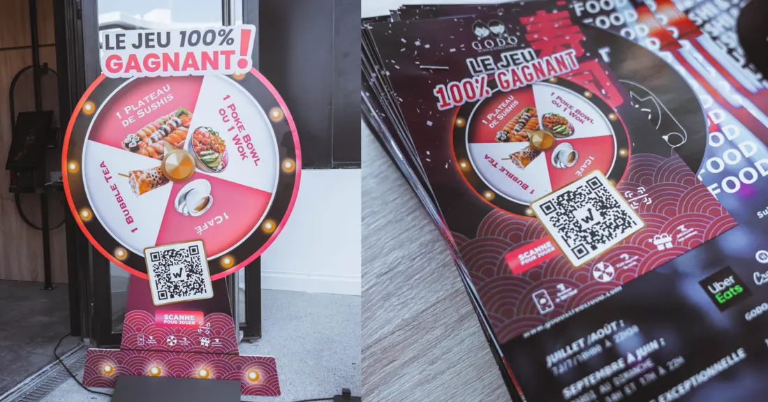 Life-size prize wheel at the Godo Sushi entrance and a stack of prize game flyers