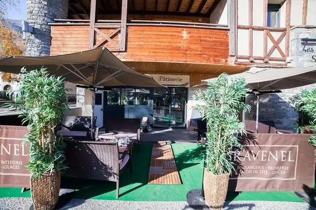 Terrasse de la boulangerie pâtisserie Maison Ravenel avec parasols, plantes et banderoles Ravenel
