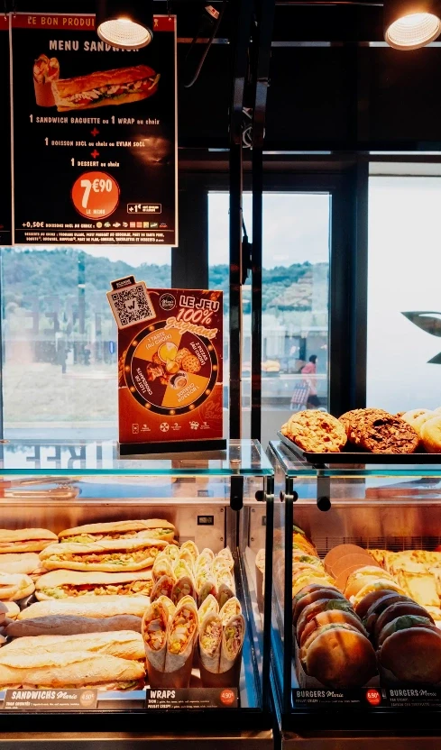 Marie Blachère sandwich and burger display with the prize game flyer on top