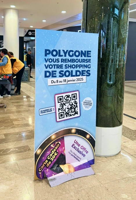 XXL roll-up banner of the prize game with QR code ('Polygone refunds your sales shopping') at the shopping centre entrance