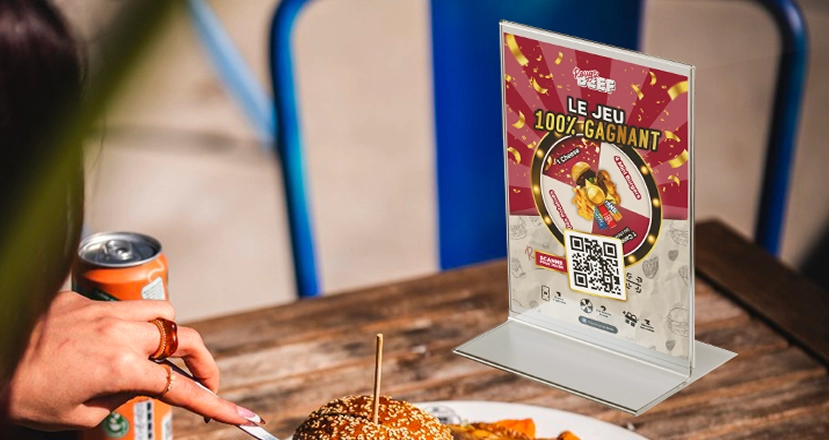 Rouge Beef prize game stand with QR code on a terrace table next to a burger