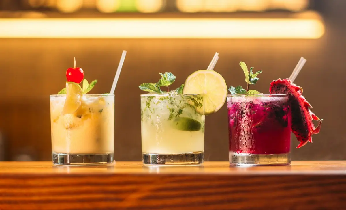 Trois cocktails colorés sur un comptoir