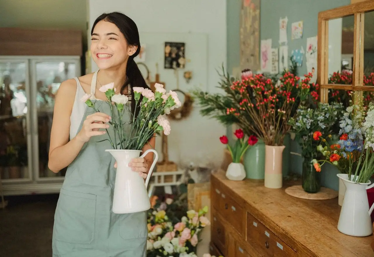 Fleuriste souriante dans sa boutique de commerce indépendant
