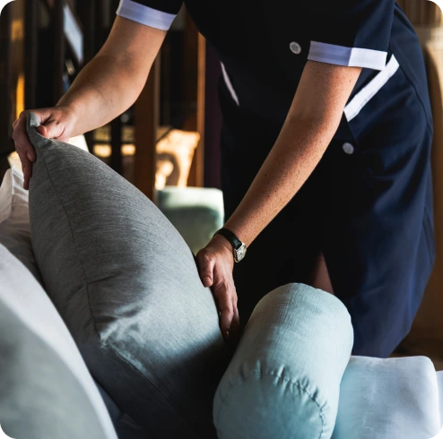 Femme de chambre preparant un lit dans une chambre d'hôtel