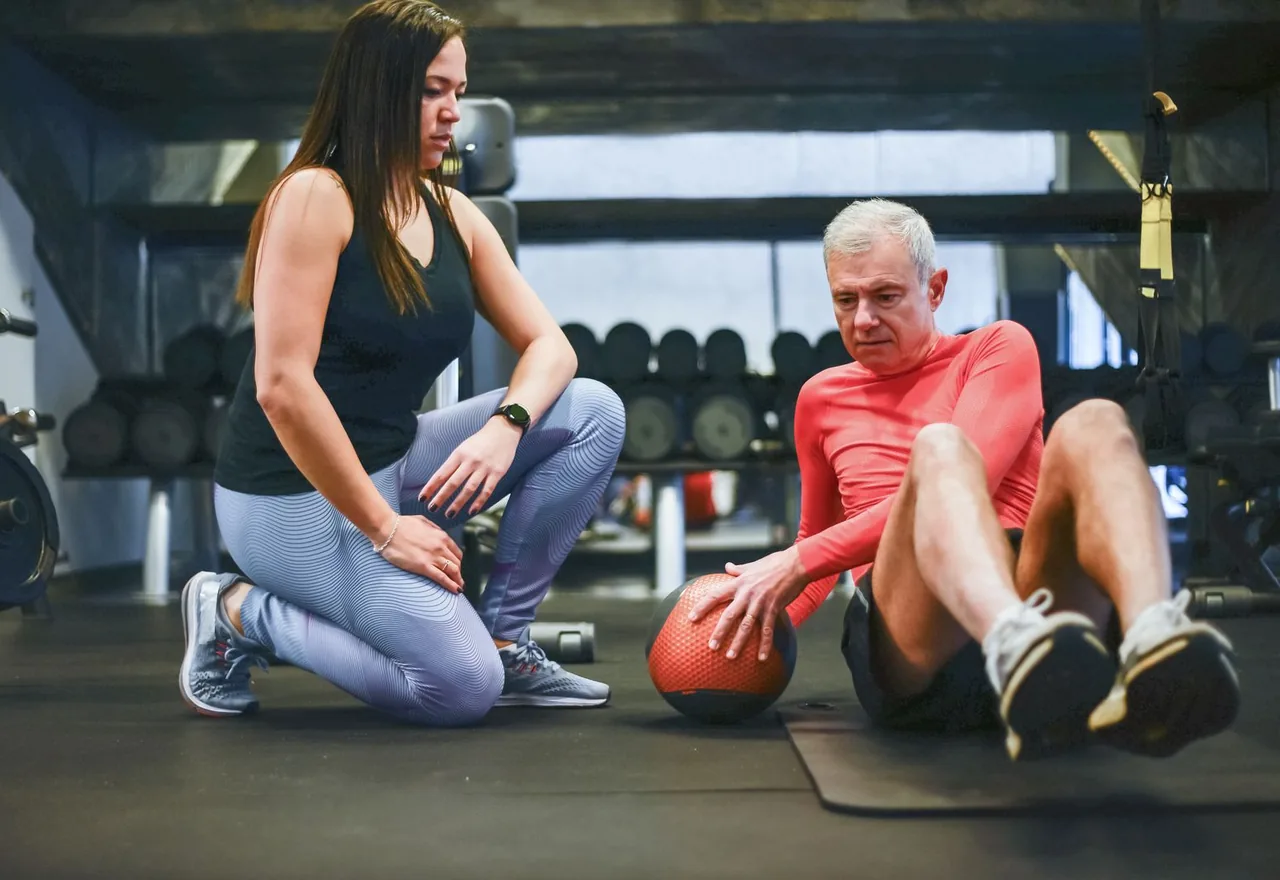 Homme et femme s'entraînant ensemble en musculation dans une salle de sport moderne